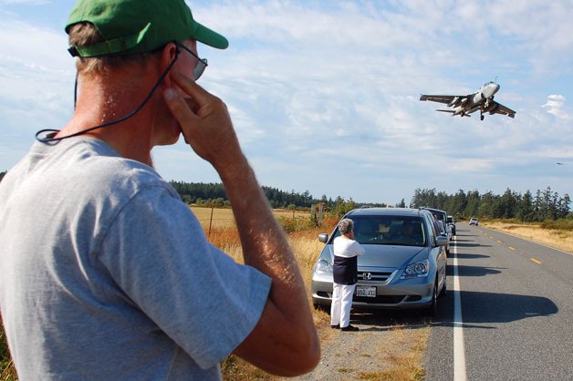 A man uses his fingers to block out the noise of a jet taking off at the U.S. Navy’s Outlying Field in Coupeville. A group opposed to flight operations at the facility  is holding a special meeting this month on jet noise and its effects on public health.