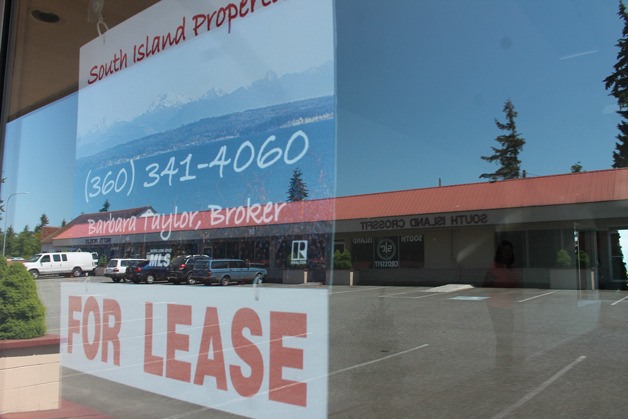 Barb Taylor checks out one of the vacancies near her business in a shopping center in Clinton. Price didn’t seem to be a deterrent at less than $1 per square foot per month with a water view.