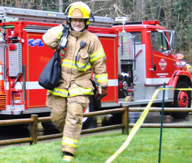 South Whidbey Fire/EMS volunteer Michael Oyola lugs his gear on a call.