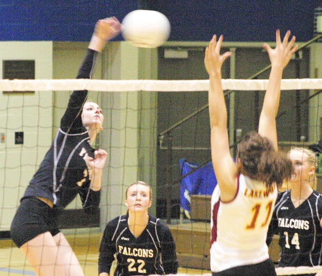 Falcon senior hitter Linden Firethorne scores a kill against Lakewood’s senior hitter Brittany Parmentier on Tuesday. Falcons sophomore Mackenzie Hezel and senior Molly Rawls cover for a dig.