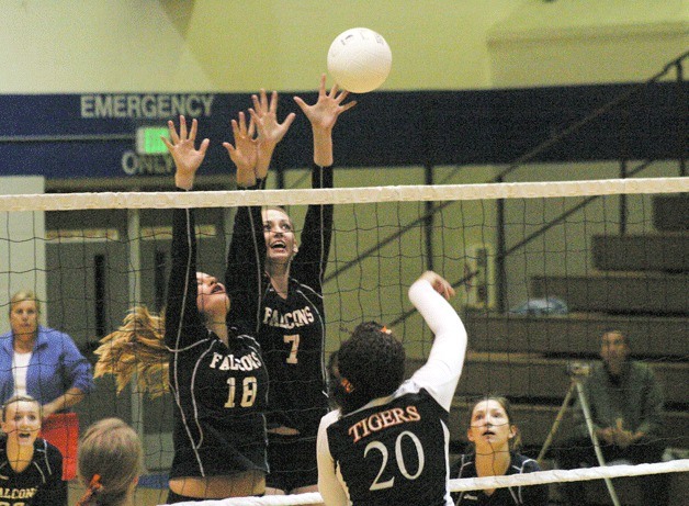 Falcons junior Hayley Newman and senior Linden Firethorne leap to block Tigers senior middle hitter Elizabeth Matalomani