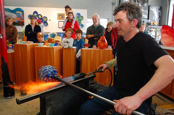 Justin Burnett / The Record Callahan McVay entertains a crowd as he works in his Second Street studio and gallery in Langley. McVay has turned his shop into a success by selling lessons