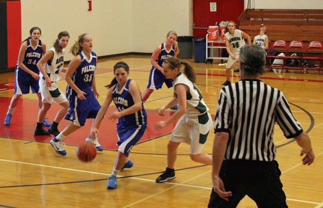 Falcon senior guard Brittany Wood resets the offense as she curls around a Madras defender during the Seaside Holiday Classic basketball tournament.