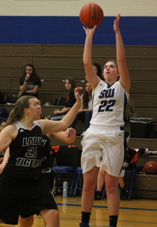 Falcon senior Abby Hodson shoots a mid-range jump shot over a couple of Tiger defenders. She led all scorers with 15 points in the blowout win for South Whidbey.