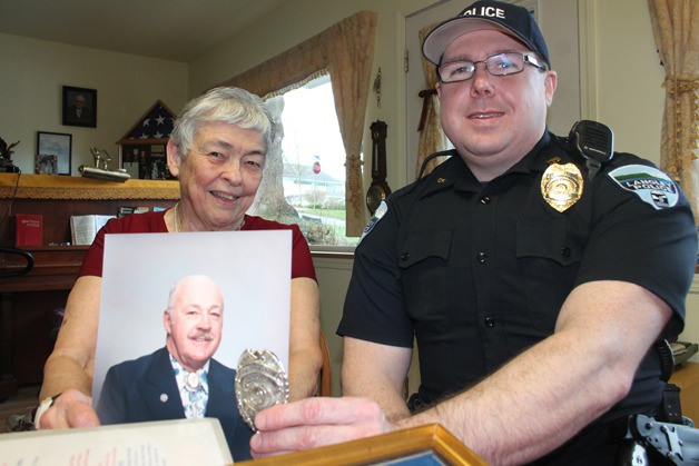 June Farrington holds up a picture of her late husband and a former Langley assistant marshal