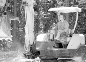 Luc d’Aignault drives his Hitachi excavator to move freezer-size boulders on second-growth forest property he owns in Langley. Sole owner of Lively Landscapes