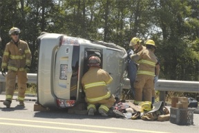 A 2006 Toyota Prius rests on its side after it was involved in a multiple car accident at Highway 525 and Double Bluff Road. Firefighters work to extract the driver