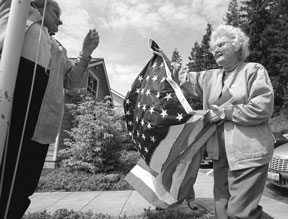 JoAnn Harmon and Betty Lehman raise a flag that flew over the U.S. Capitol at the Freeland Library Friday as a preview to Memorial Day.