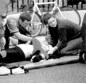 Paramedics Darin Reid and Angela West work on bicyclist Gary Warstler after a Monday morning bicycle accident near the Clinton ferry dock.