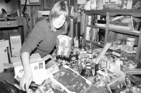 Cathy Caryl packs a care package for a soldier in Iraq in her home office headquarters.