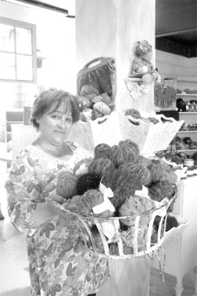 Knitty Pearls owner Kristine West displays some of the yarns she has available at the store.