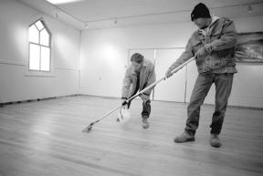 Local Hardwood and Tile employees Roc Dahle and Michael Rosseau put down a coat of sealer on the newly exposed maple floor at the Deer Lagoon Grange. The company donated the labor on the floor.