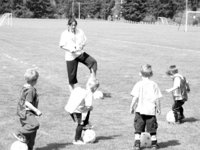 South Whidbey Parks & Recreation coach Sami Todoroff guides some very young folks through the mysteries of soccer at the complex on Langley Road. Professional coaches teach the fundamentals in the Kidz Love Soccer program this summer.