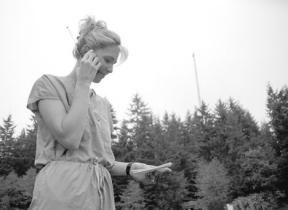 Wendi Bueler looks for just the right spot to call on her cell phone at Ken's Korner Shopping Center. The new T-Mobile cell tower behind her should boost cell signals for callers signed up with a number of phone companies.