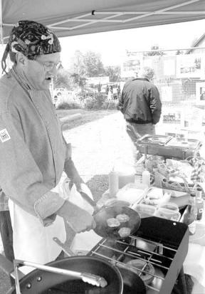 Langley resident Tim Goeken -- who owns a gourmet private chef business -- sears crab cakes at the Bayview Farmer's Market in May.