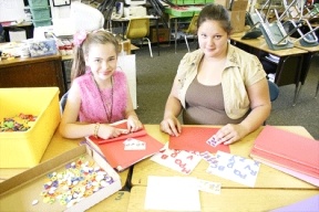 Langley Middle School students Stephanie Otteman and Norah Helley work on the next set of Memorial Day Cards for deployed troops.