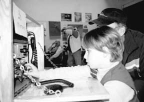 Freeland Girl Scout Ellie Robbins takes charge of the radio with supervision as other Scouts look on.