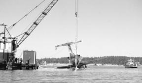 A crane on a barge lifts the two-engine Cessna Citation jet from Penn Cove on July 24