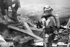 District 3 firefighter Christopher Callahan pauses during a training exercise Saturday at a house fire on Shore Avenue in Freeland. The intentional fire was used as a training device for new and current members of the department.