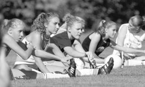 Freshmen Lucy Brennan and Jenna Wild stretch before their first practice of the season Monday. Their team