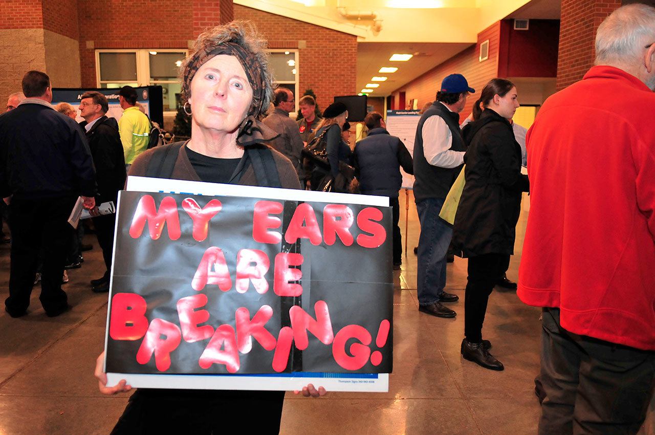 Michael Watkins / Whidbey News Group                                An unidentified woman holds up a sign about jet noise at a public meeting in Coupeville on Friday nihgt.