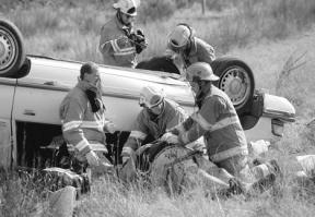 Firefighters and emergency medical technicians work Saturday to get Langley resident Bobby Wimberly on a backboard before moving him into a waiting ambulance after a three-car accident on Highway 525 near Howard Road.