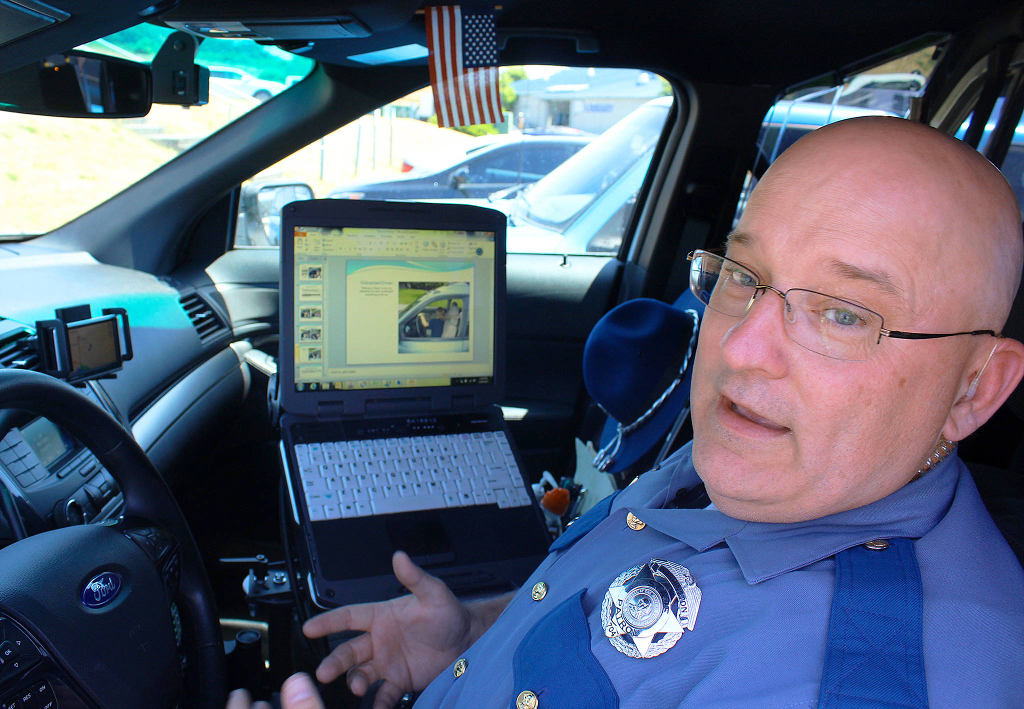 Beginning Sunday it’s illegal under a new state law to have a cell phone or any electronic device in your hand while driving. State trooper Dave Martin advises: “Just focus on getting from point A to point B.”                                Photo by Patricia Guthrie/Whidbey News-Times