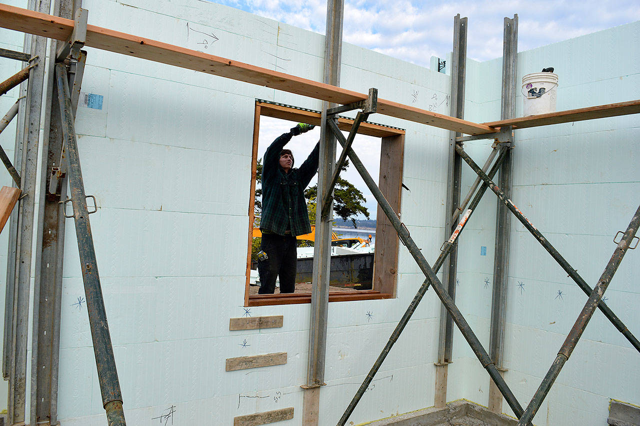 Nevin Miranda of Viewridge Construction installs a window frame on a new house being built on Leach St NE. The county recently released a survey to determine residents’ satisfaction with housing in Island County. Photo by Laura Guido/Whidbey News-Times