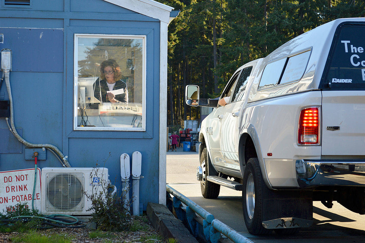 Bernadette Martell, a solid waste attendant, processes a payment at the solid waste transfer station in Coupeville. The county is working to make it so customers can eventually pay with a credit card. To make cash transactions easier, the complex currently rounds fees up to the nearest 50 cents—something public works is also trying to change. Photo by Laura Guido/Whidbey News-Times