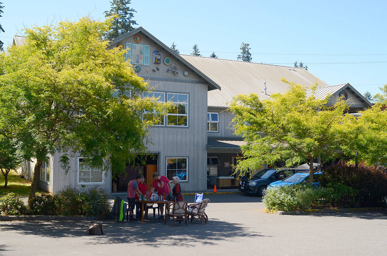 Record file — Island Senior Resources and Senior Thrift employees gather at a make-shift office in the thrift shop’s parking lot in July. The store has been closed since a fire damaged the building, but it will reopen on Black Friday.