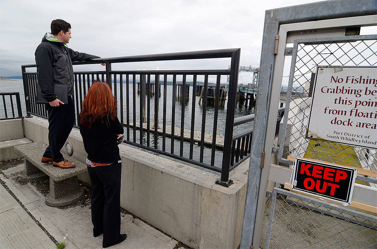 Record file — Byron Haley and Margaret Schwetner of the engineering firm Moffatt & Nichol look at the Clinton Beach Dock in 2016. Repairs on the dock will cost Port of South Whidbey $27,000.