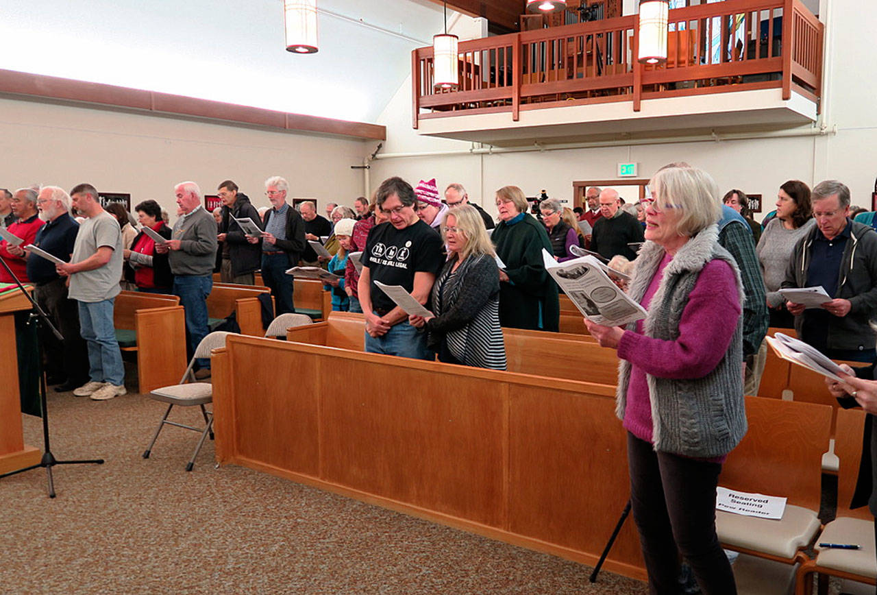 Dick Hall photo — Guests at St. Augustine’s sing in unison at the church’s 2017 MLK Day program. This year’s event will connect King’s words to today’s current political climate.