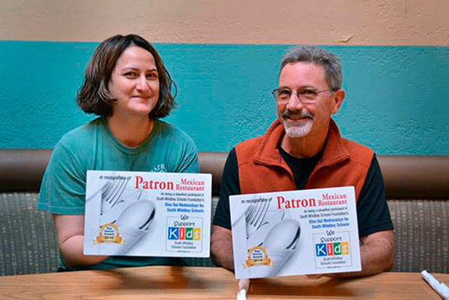 Patron Mexican restaurant’s manager Anna Campante and School Foundation president Chris Gibson hold some of the Dine Out for South Whidbey Schools recognition plaques the restaurant has received. Photo provided.