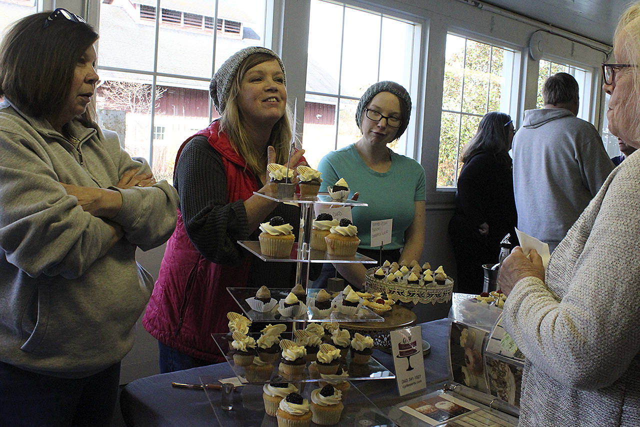 Yvonne Hurt (center) of Cj &Y Decadent Desserts serves up tiers of treats at a Whidbey Island Grown event recently at Greenbank Farm.