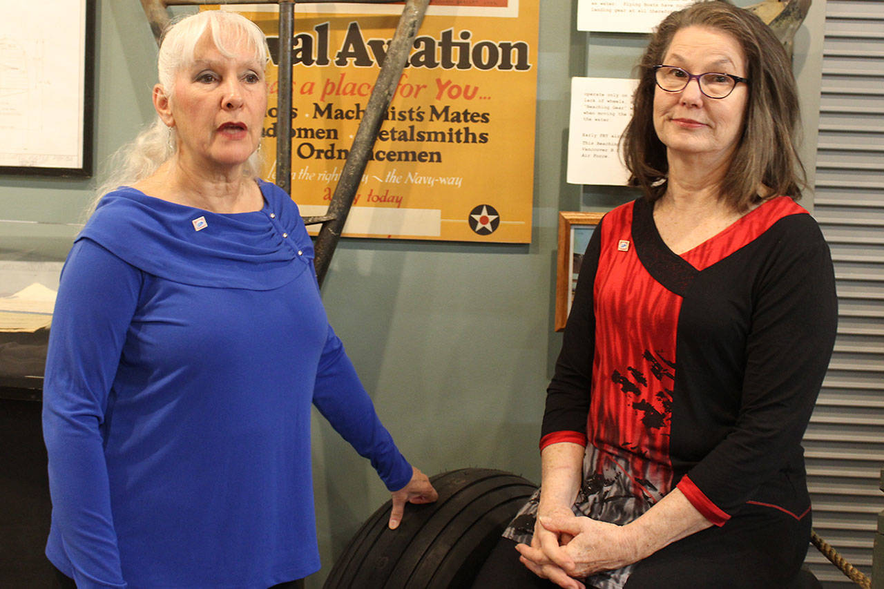 Writers Deborah Fisher (left) and Kellen Diamanti posed inside Oak Harbor’s PBY Naval Air Museum before leaving for ceremonies launching their book, “Stamp of the Century.” Photo by Patricia Guthrie/Whidbey News Group