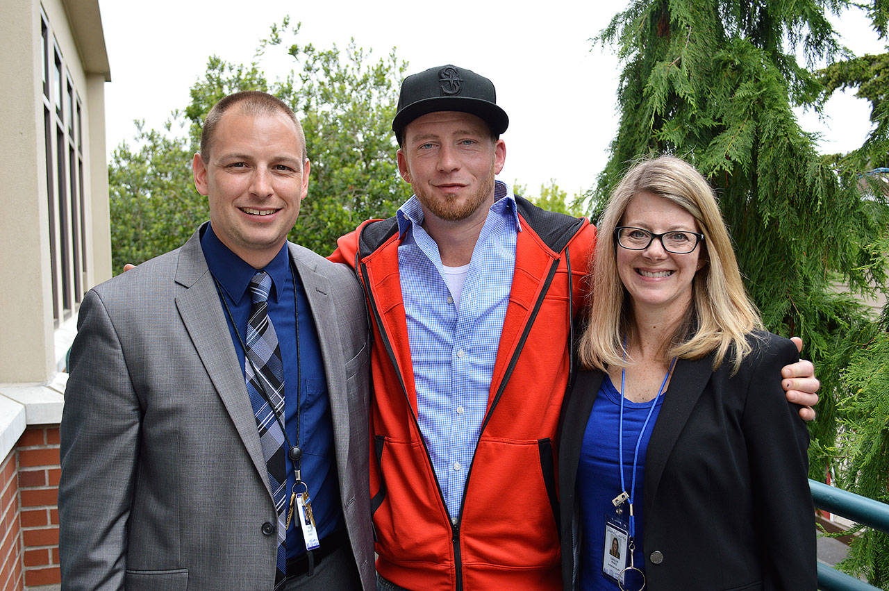 Recent drug court graduate Conrad Standinger, center, stands with his case manager Ken Delano and Carolyn Pence, drug court coordinator. His accomplishments were recently celebrated by staff and other participants in the program during Island County Drug Court Month. Photo by Laura Guido/Whidbey News Group