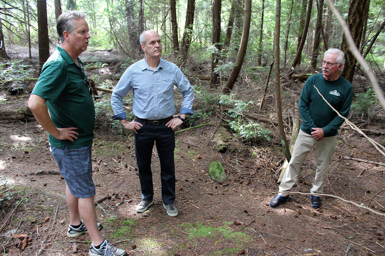 U.S. Rep. Rick Larsen listens to Doug Coutts, left, South Whidbey Parks Recreation District director, and Dennis Hunter, district commissioner, right, talk about the need to acquire 40 acres of private land before it’s logged and sold to developers. Larsen took a tour of the woods Friday morning. Photo by Patricia Guthrie/Whidbey News Group