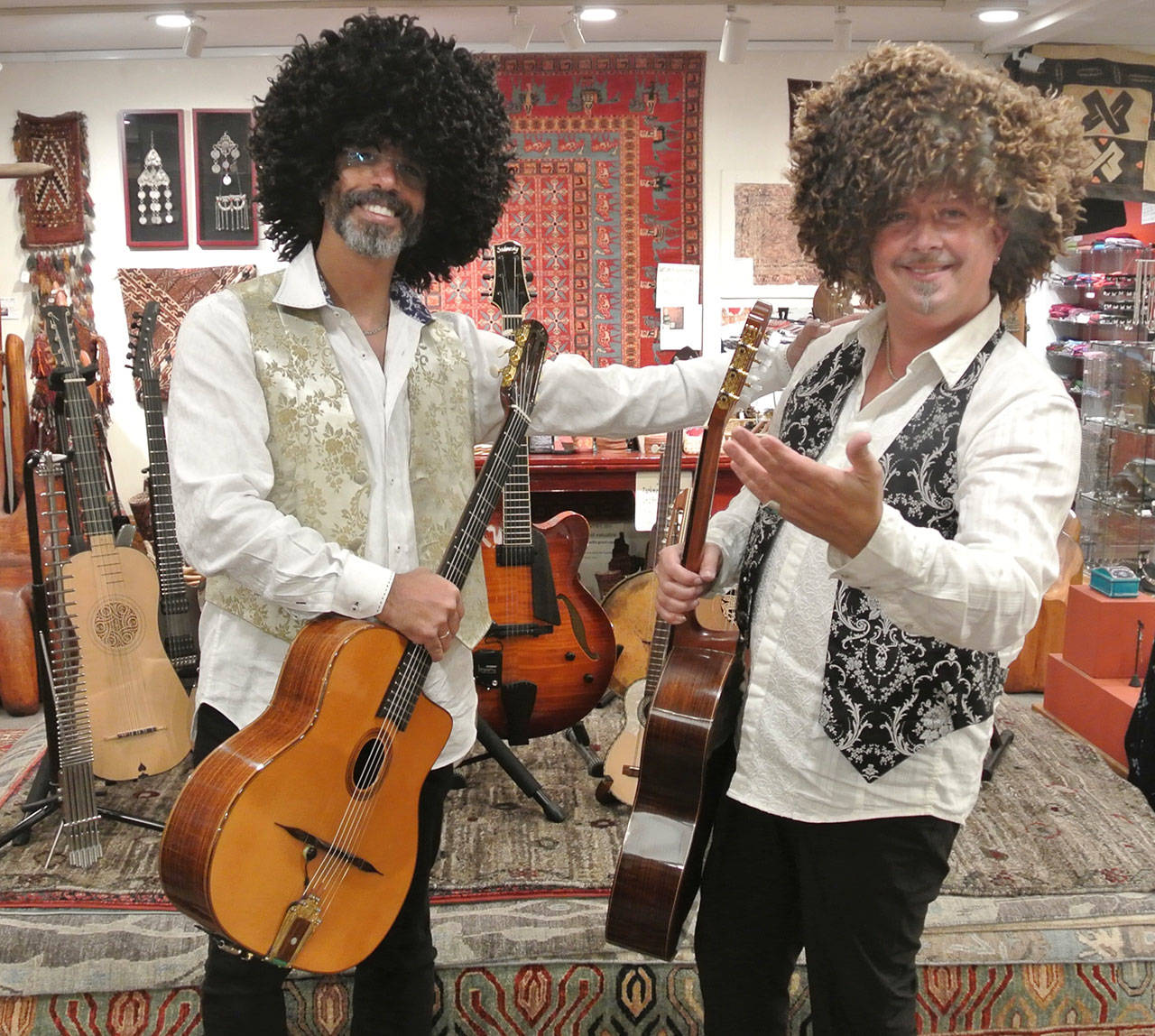 Troy Chapman, left, and Andre Feriante try on some Turkmenistan hats while posing for photos at Music for the Eyes in Langley. (Photo provided by Julie Quiring)