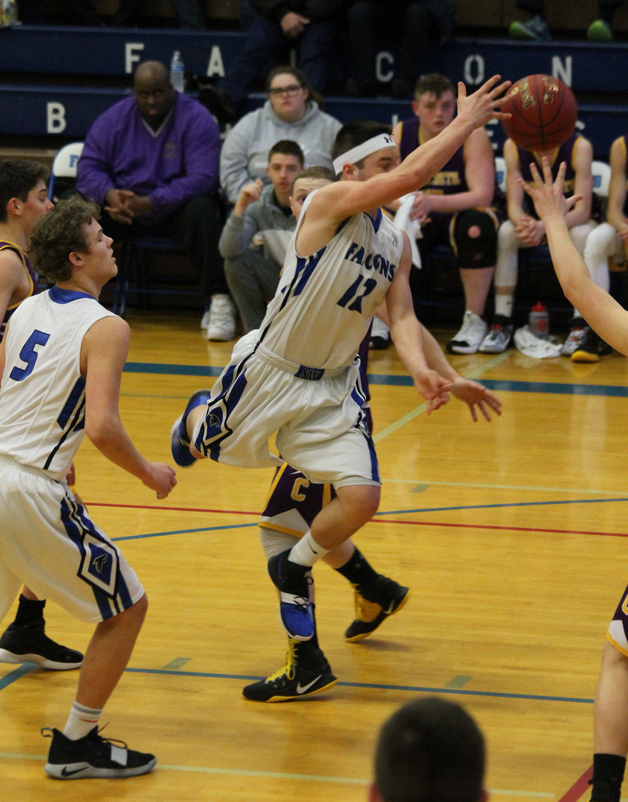 Dexter Jokinen dishes off after attacking the lane in South Whidbey’s big win over Concrete.(Photo by Jim Waller/South Whidbey Record)