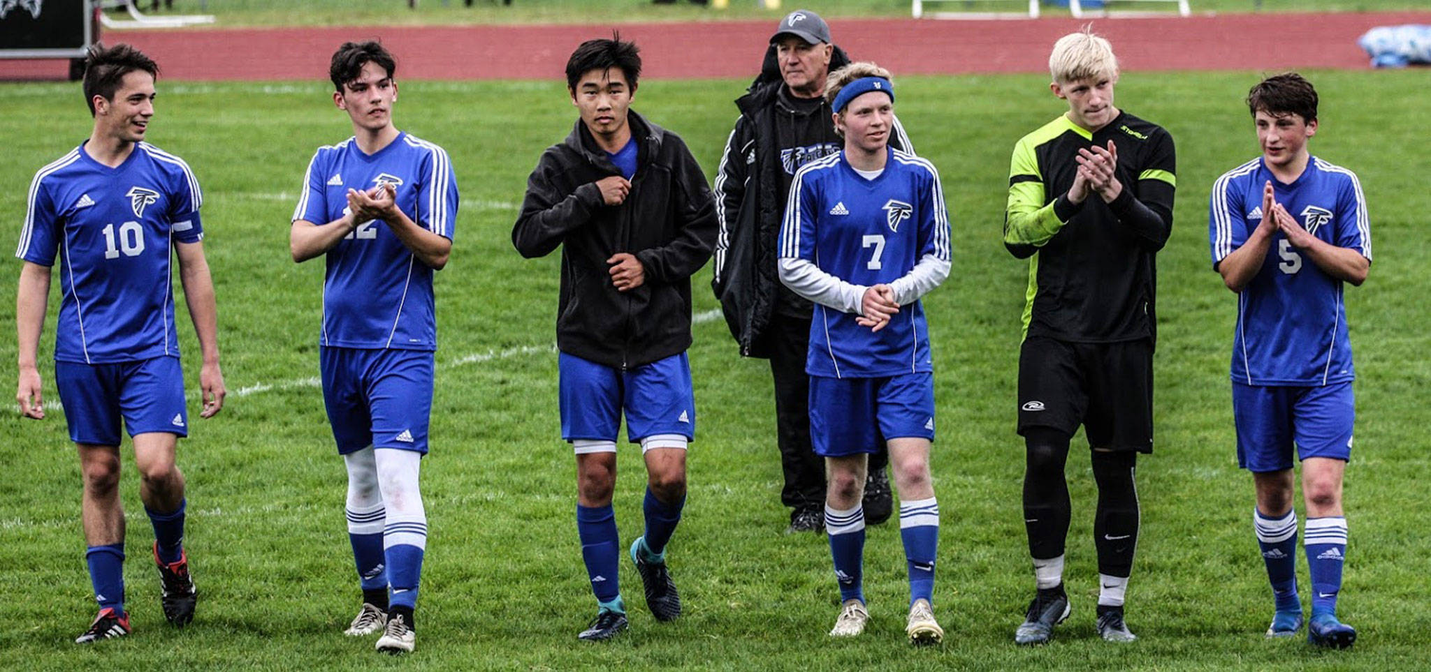 The South Whidbey seniors acknowledge the crowd during their recognition ceremony at halftime Friday. From the left are Michael Lux, Nevin Daniels, Graham Colar, Eli Waldron, Julian Inches and Cormac Workman. In the back is coach Emerson Robbins.(Photo by Matt Simms)