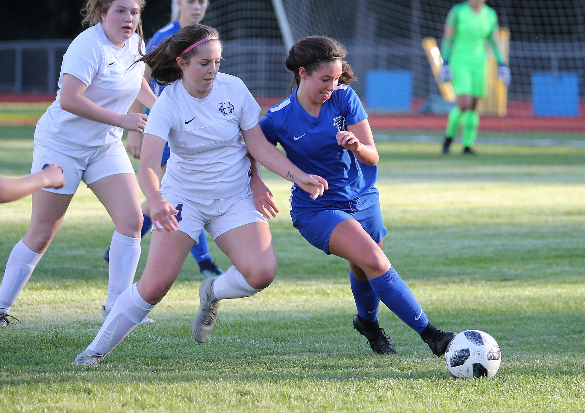 Kelly Murnane, right, beats Oak Harbor’s Peyton Rhyne to the ball in the Falcons’ win Tuesday.(Photo by John Fisken)