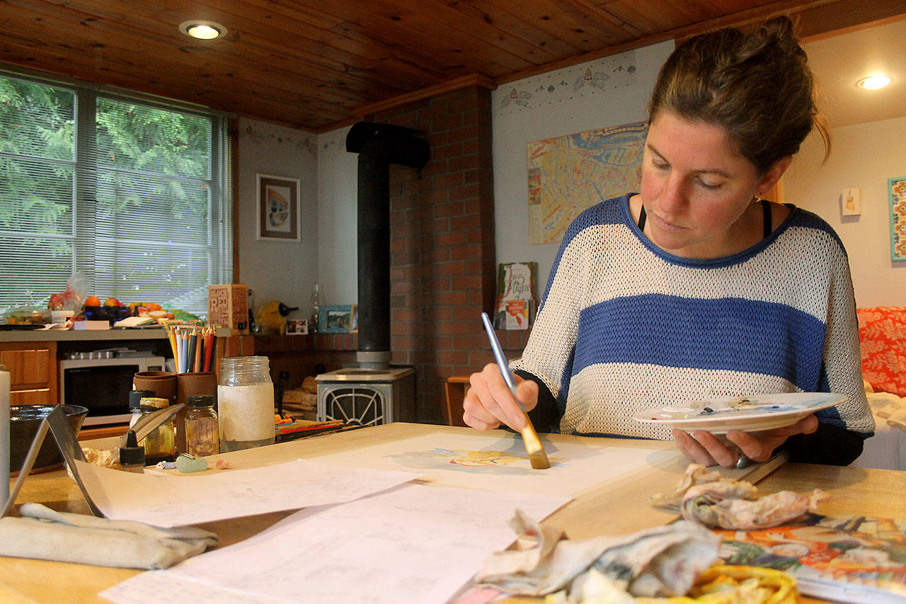 Photo by Kira Erickson / South Whidbey Record                                Anna Cosper paints a design for a commissioned holiday card in her studio.