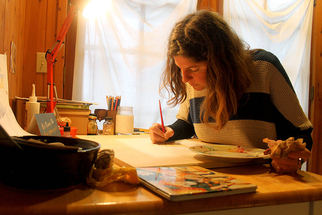 Photo by Kira Erickson / South Whidbey Record                                Anna Cosper paints a design for a commissioned holiday card in her studio.