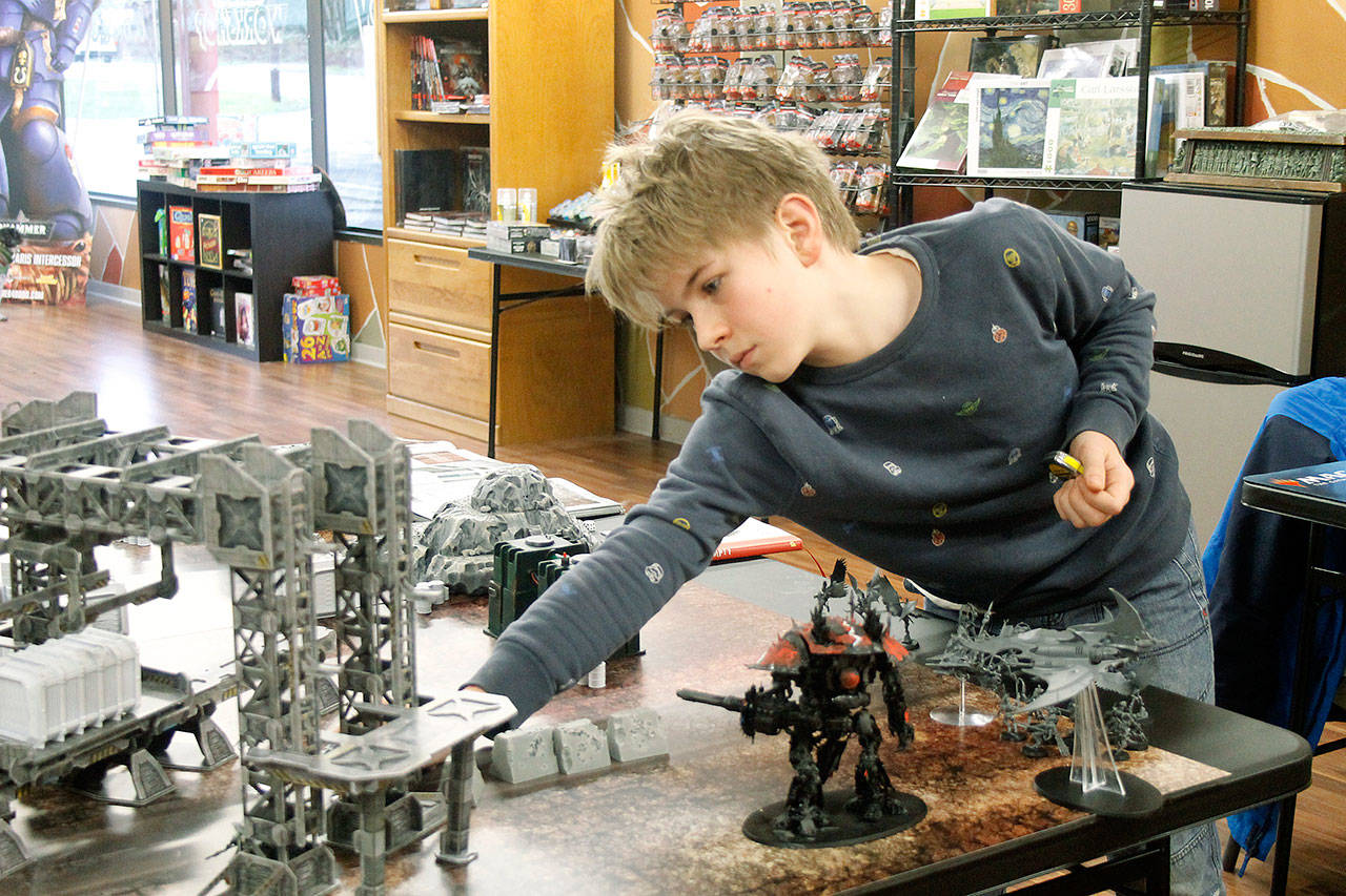 Photos by Kira Erickson/Whidbey News Group                                Harper Neff moves his warrior under cover during a game of Warhammer on Jan. 22.