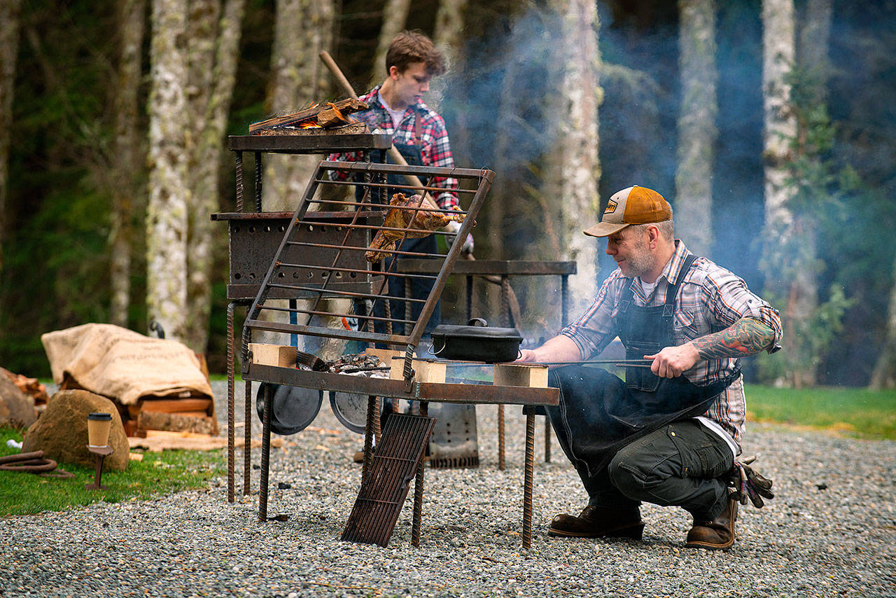 Photo provided                                Chef JP Dowdell, right, and firemaster Baron Molo cook food on a fire table of Dowdell’s creation.