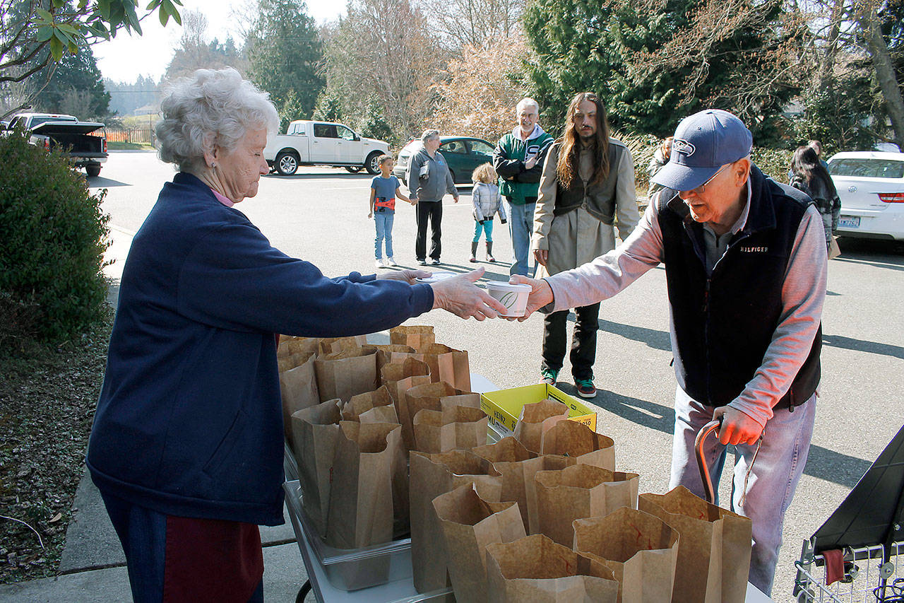 Photo by Kira Erickson/Whidbey News Group                                Coordinator Jean Matheny exchanges soup with Rick Klein, a former longtime volunteer in the Island Church soup kitchen.