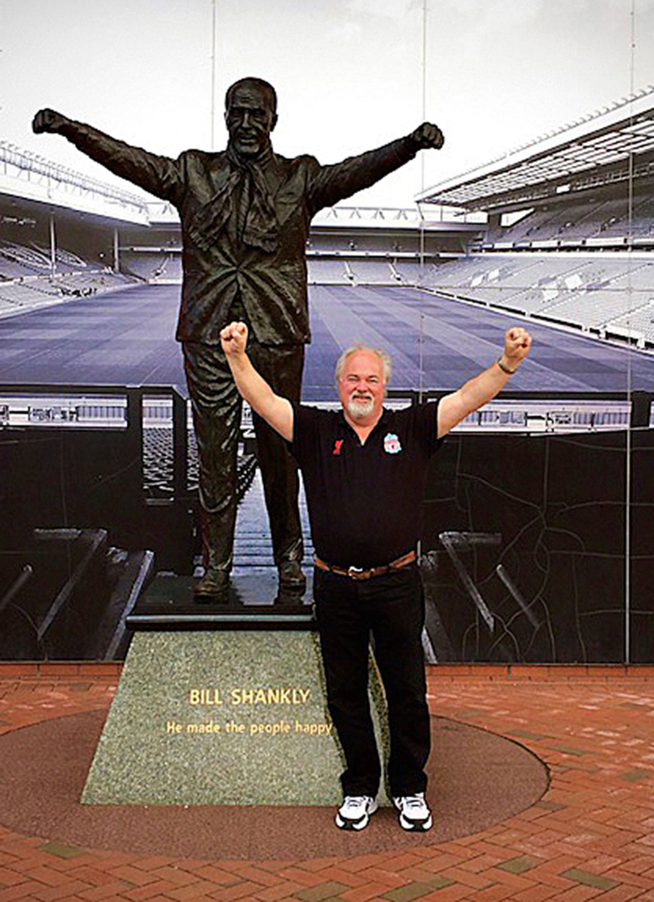 Crispin Roberts stands next to the statue of Bill Shankly outside Liverpool’s soccer stadium. (Provided photo)