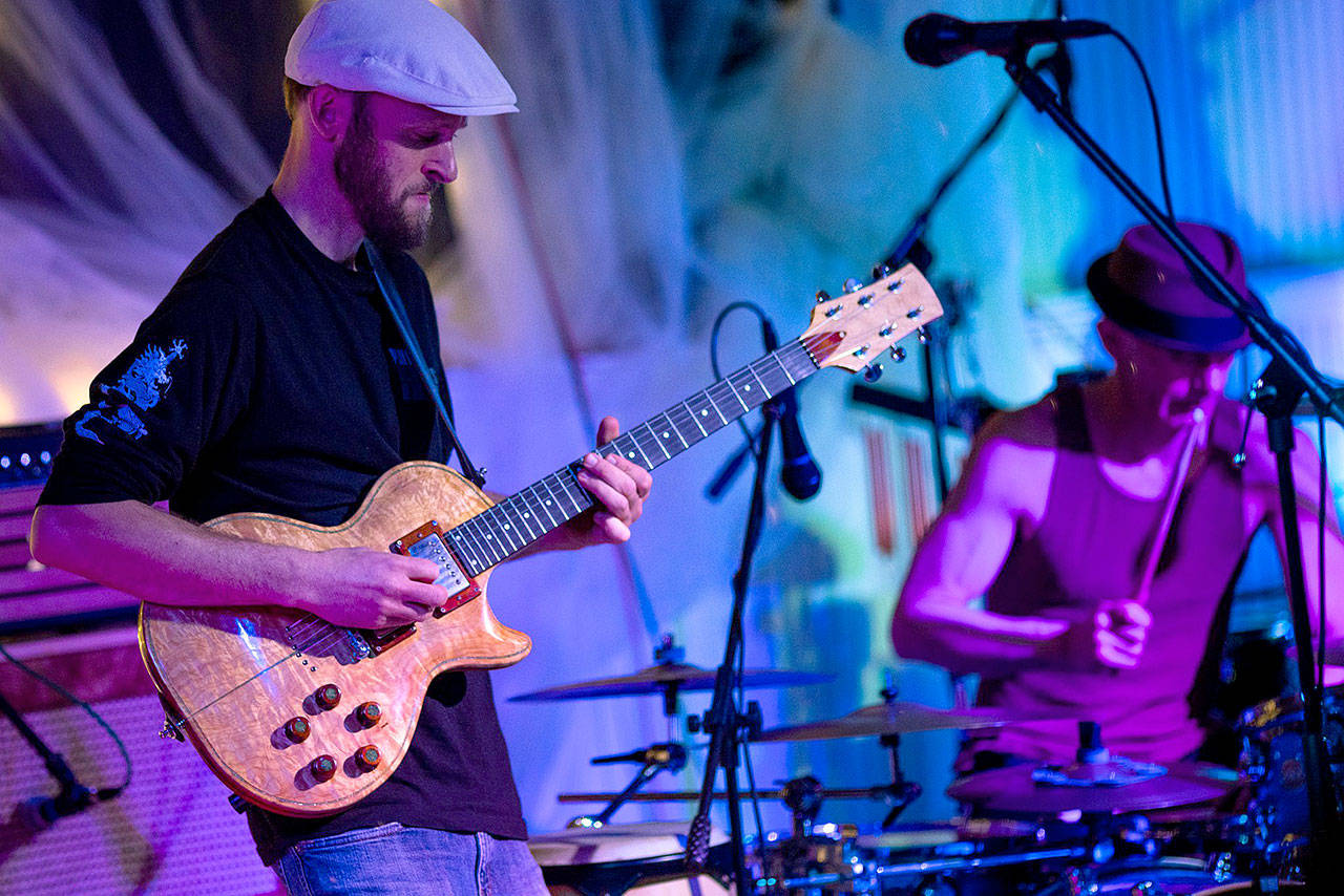 Photo by Daniel Hale                                Guitarist Eric Conn performs during a New Year’s Eve show at Bayview Hall. His guitar is homemade, built from wood from the Pacific Northwest.