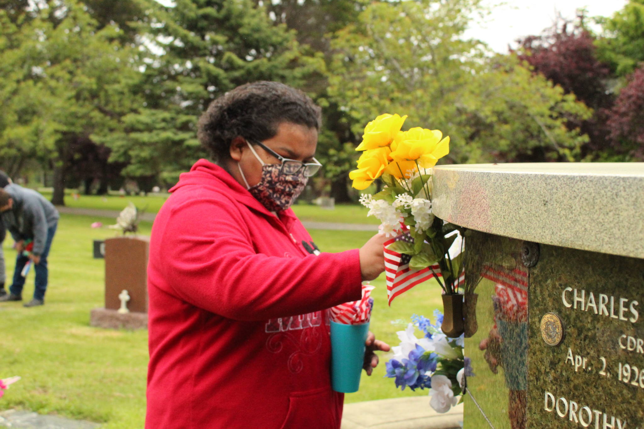 Exceptional Academy student Chloe Foster-Blythe adorns a veteran’s grave with an American flag at Maple Leaf Cemetery in Oak Harbor, May 17, 2021. (Photos by Karina Andrew/Whidbey News-Times)