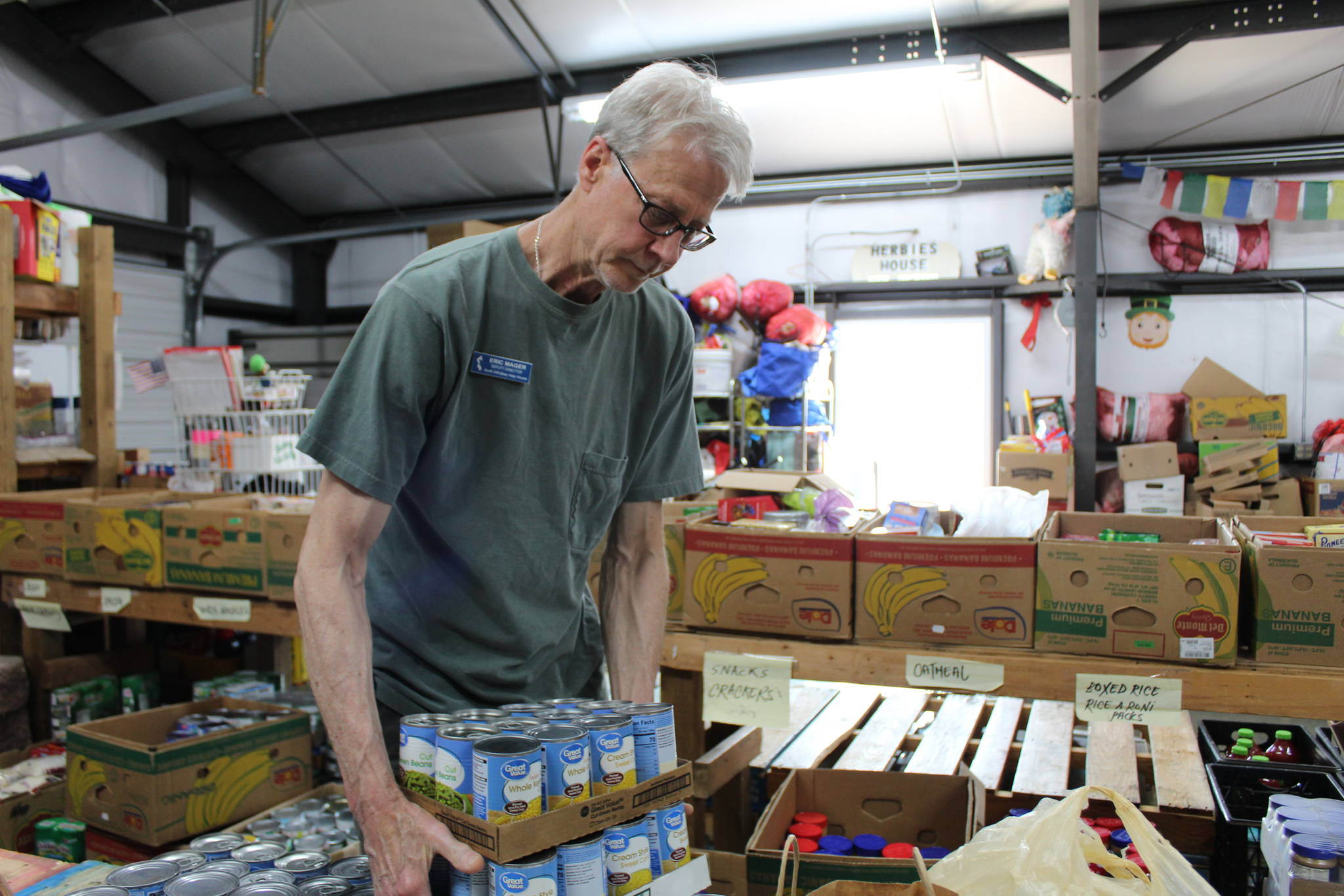 North Whidbey Help House deputy director Eric Mager stocks food in the warehouse. (Photo by Karina Andrew/Whidbey News-Times)